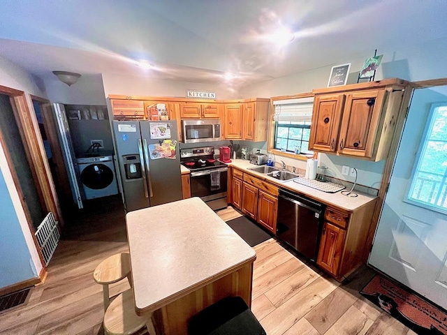 384 Shadow Pines Dr, Murphy, NC 28906 - kitchen featuring appliances with stainless steel finishes, washer / clothes dryer, a sink, light wood finished floors, and light countertops