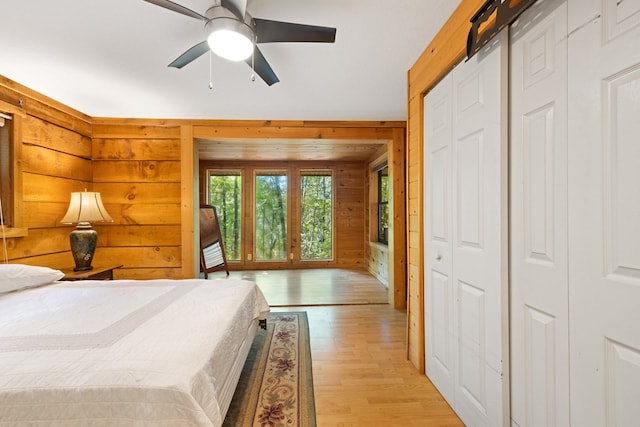 881 Sawyer Cove Rd, Hayesville, NC 28904 - bedroom with wood walls, light wood-style floors, and a ceiling fan