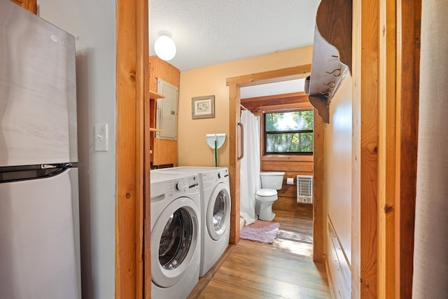 881 Sawyer Cove Rd, Hayesville, NC 28904 - washroom featuring separate washer and dryer, wood finished floors, a textured ceiling, and heating unit