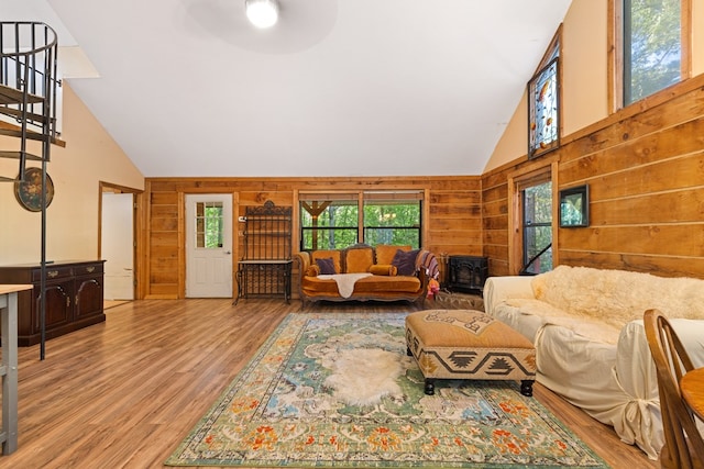 881 Sawyer Cove Rd, Hayesville, NC 28904 - living area with high vaulted ceiling, wooden walls, light wood-style flooring, a ceiling fan, and a wood stove
