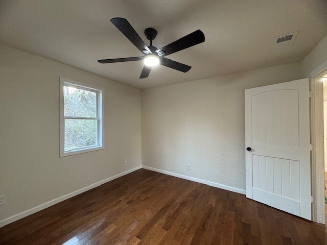 empty room featuring dark hardwood / wood-style floors and ceiling fan