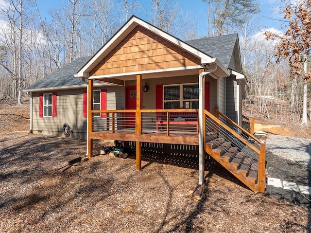 view of front facade featuring covered porch and roof with shingles