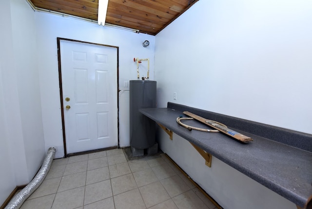 interior space featuring water heater, light tile patterned flooring, and wooden ceiling