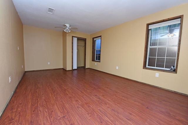 empty room with dark hardwood / wood-style floors and ceiling fan