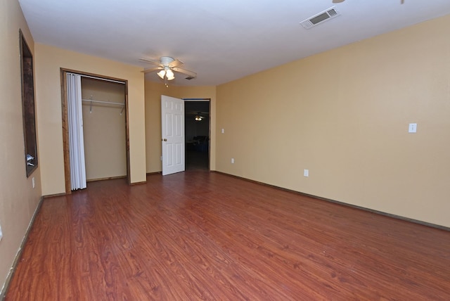 unfurnished bedroom featuring dark hardwood / wood-style flooring, a closet, and ceiling fan