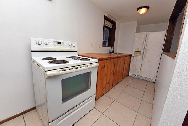 kitchen with light tile patterned flooring, white appliances, and sink