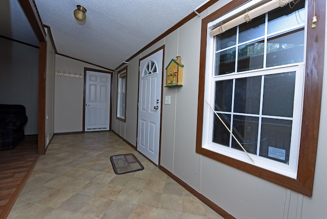 corridor featuring ornamental molding, a textured ceiling, and vaulted ceiling