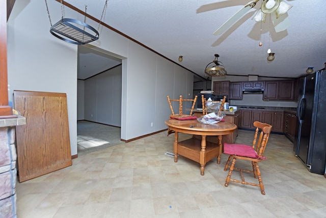 dining area featuring lofted ceiling, a textured ceiling, ceiling fan, and crown molding