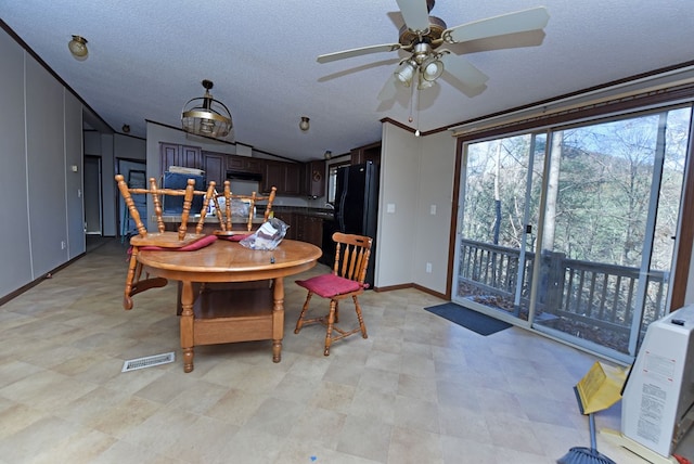 dining area featuring lofted ceiling, ceiling fan, and a textured ceiling