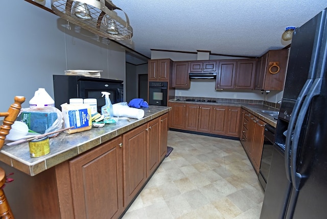 kitchen featuring a textured ceiling, lofted ceiling, and black appliances