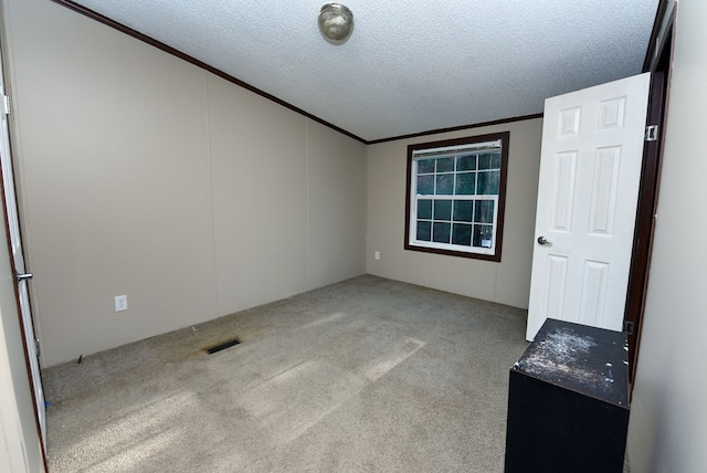 unfurnished room featuring ornamental molding, a textured ceiling, and light carpet