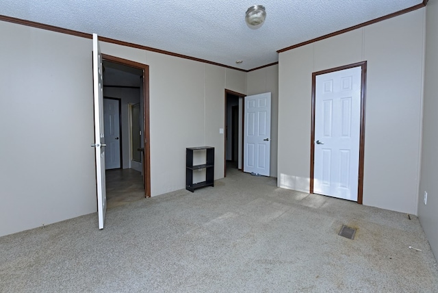 unfurnished bedroom featuring light carpet, crown molding, and a textured ceiling