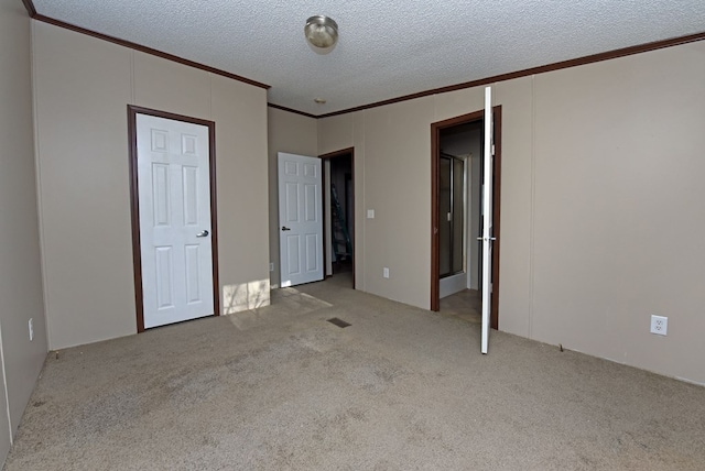 unfurnished bedroom featuring crown molding, light colored carpet, and a textured ceiling