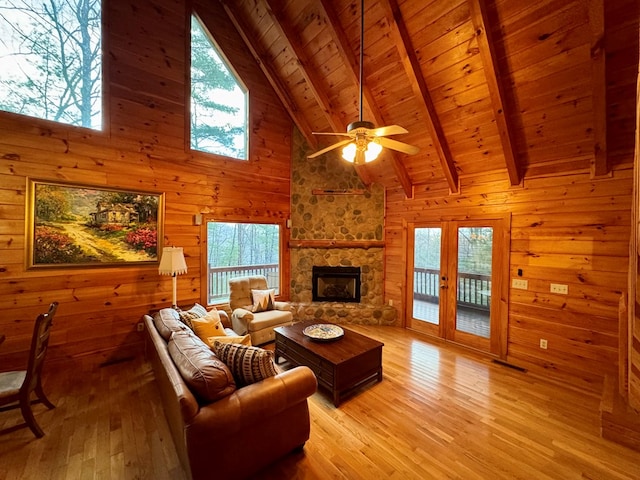 living room featuring wooden walls, ceiling fan, wood ceiling, light wood-type flooring, and beam ceiling