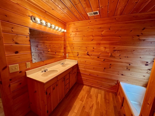 full bath featuring visible vents, a sink, wood finished floors, double vanity, and wood ceiling