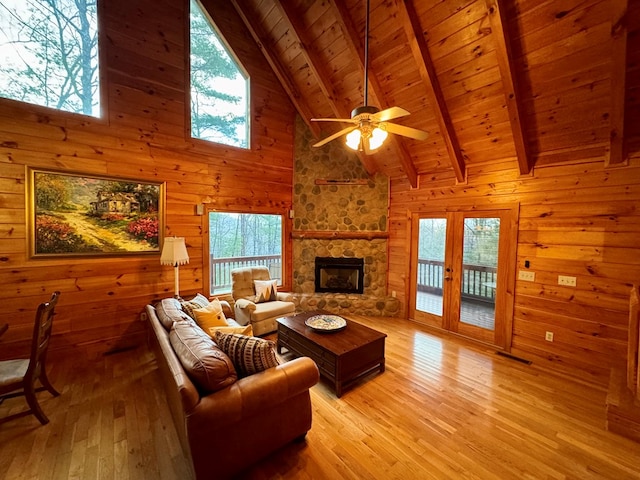 living room featuring wooden ceiling, beamed ceiling, light wood finished floors, and wood walls