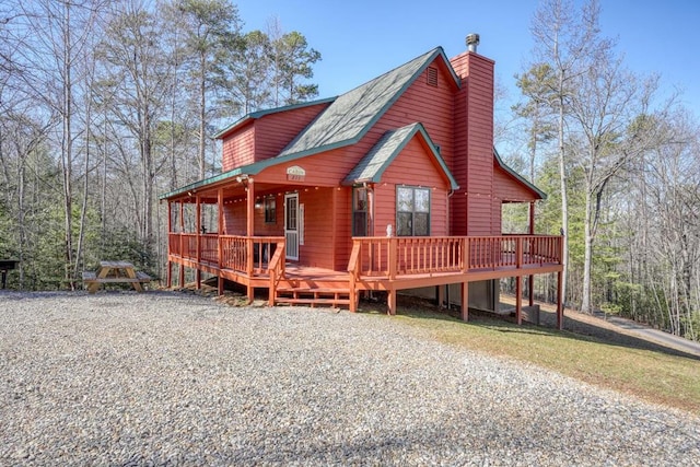 chalet / cabin with a chimney and a wooden deck