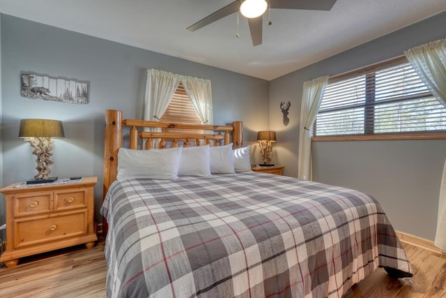 bedroom featuring ceiling fan, light wood-type flooring, and baseboards