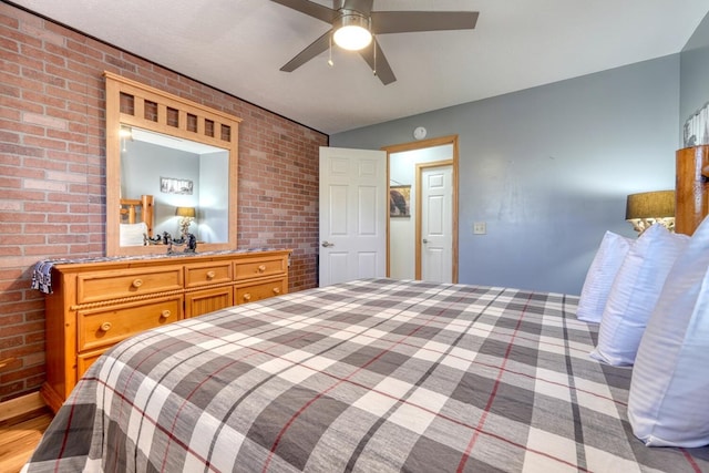 bedroom with brick wall and a ceiling fan