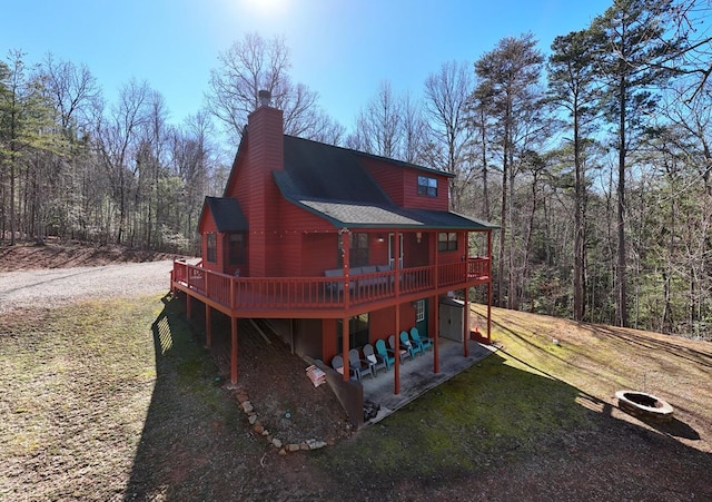 back of house with a yard, a patio, a shingled roof, and a wooden deck