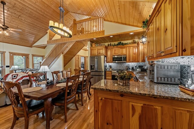 2487 Newport Dr, Ellijay, GA 30540 - kitchen with a ceiling fan, wood ceiling, stainless steel appliances, brown cabinets, and decorative backsplash