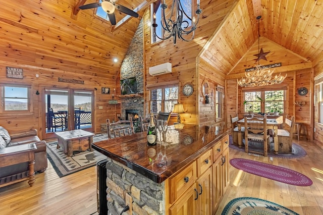 kitchen featuring an AC wall unit, a fireplace, wood walls, a center island, and french doors