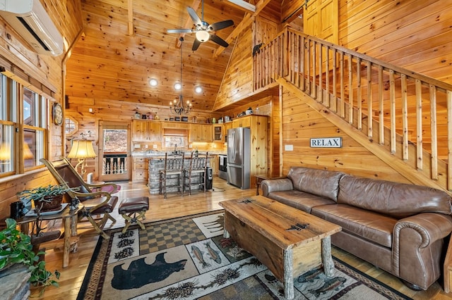 living room featuring wooden walls, a wall mounted AC, light hardwood / wood-style floors, ceiling fan with notable chandelier, and wooden ceiling