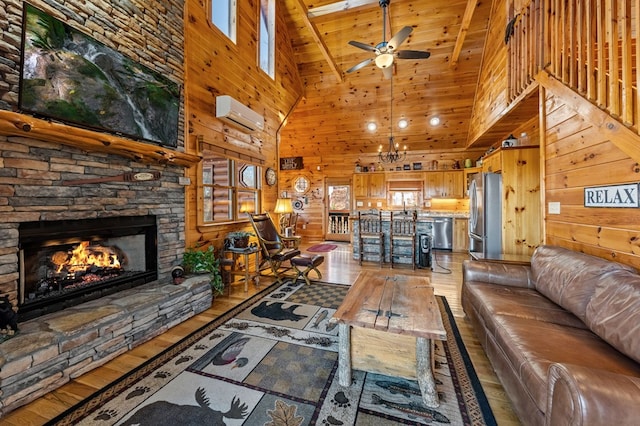 living room with a wall mounted air conditioner, wood-type flooring, wooden walls, ceiling fan, and a fireplace