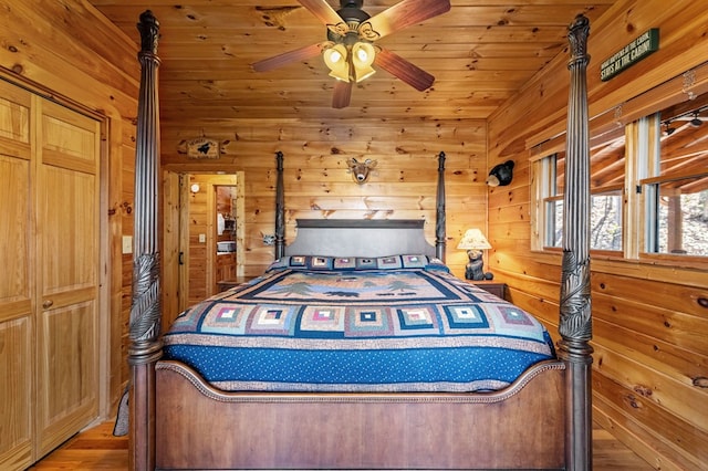 bedroom featuring wood-type flooring, wooden ceiling, ceiling fan, and wood walls