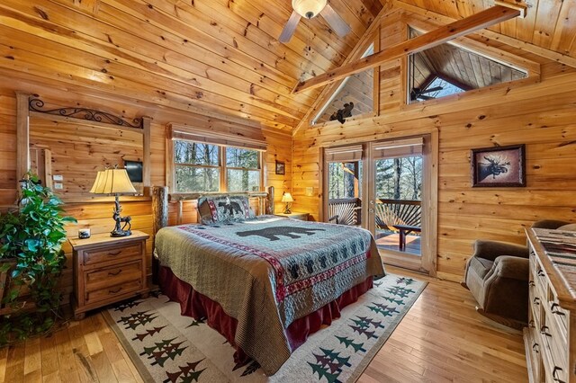 bedroom featuring wooden walls, access to outside, wood ceiling, and light hardwood / wood-style floors