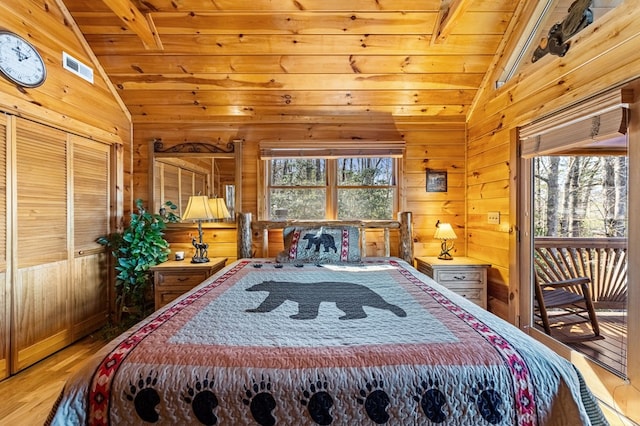 bedroom featuring hardwood / wood-style flooring, vaulted ceiling with beams, wood ceiling, and wood walls