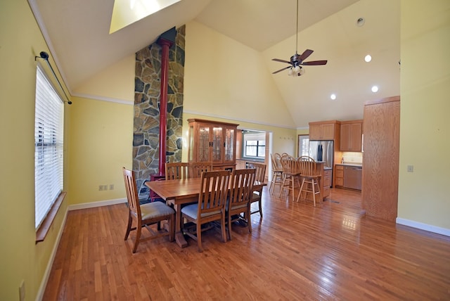 dining area featuring hardwood / wood-style floors, high vaulted ceiling, and ceiling fan