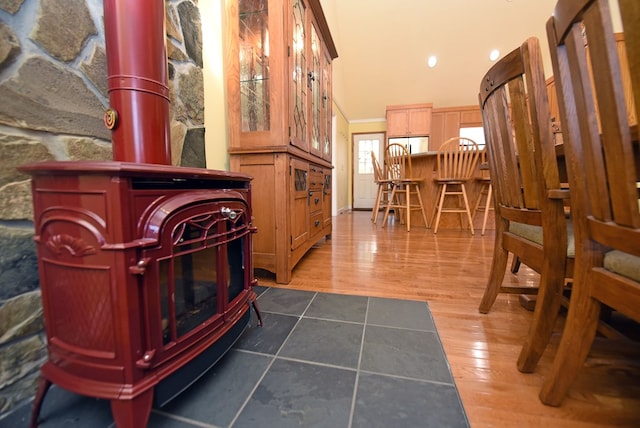 sitting room with dark wood-type flooring, a towering ceiling, and a wood stove