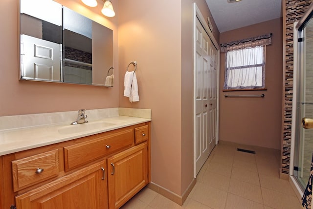 bathroom with vanity, tile patterned flooring, and a textured ceiling