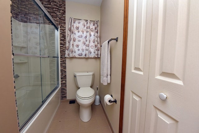 bathroom featuring enclosed tub / shower combo, tile patterned floors, and toilet