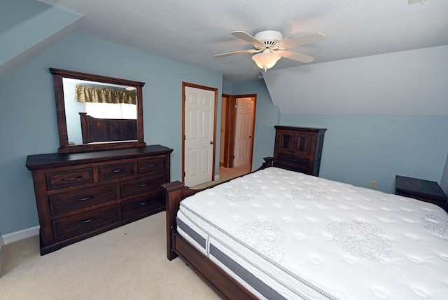 carpeted bedroom featuring ceiling fan, vaulted ceiling, and a textured ceiling