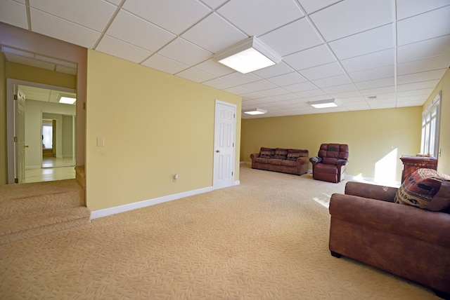 carpeted living room with a paneled ceiling