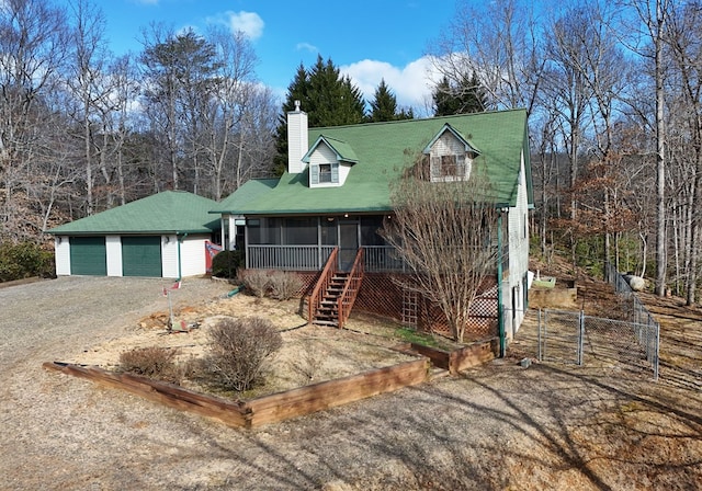 view of front of property with a garage, an outdoor structure, and a sunroom