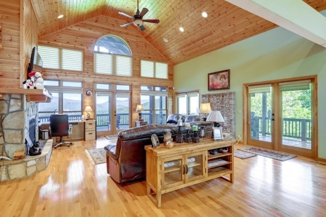 living room with light hardwood / wood-style flooring, french doors, high vaulted ceiling, and a wealth of natural light