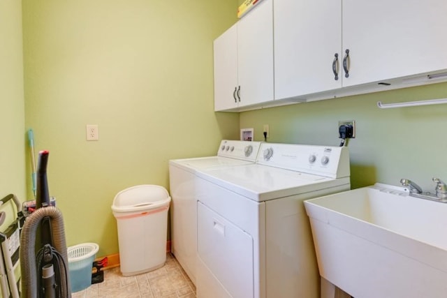 washroom featuring sink, washing machine and dryer, and cabinets