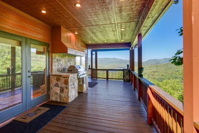 deck with a mountain view, area for grilling, and an outdoor kitchen