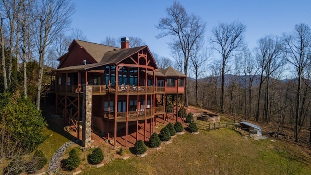 back of property featuring a deck and a lawn