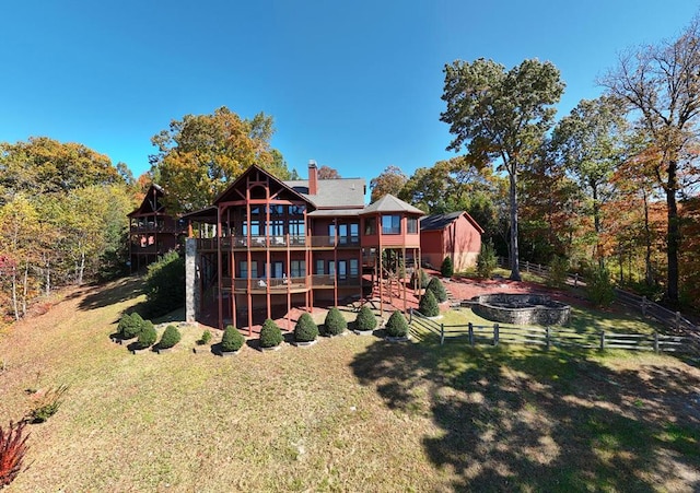 back of house featuring a deck and a lawn