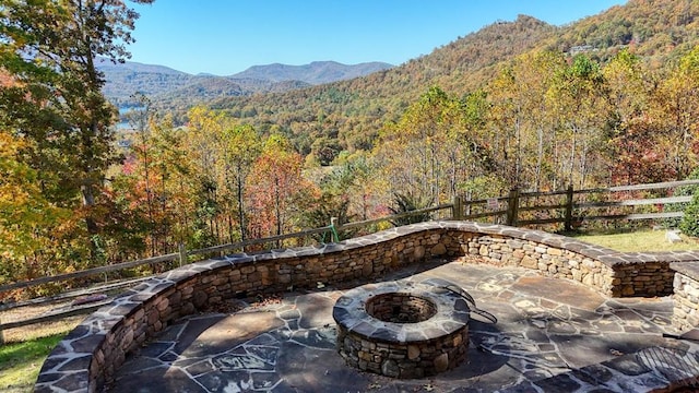 view of patio with an outdoor fire pit and a mountain view