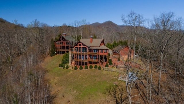 rear view of property featuring a lawn and a deck with mountain view