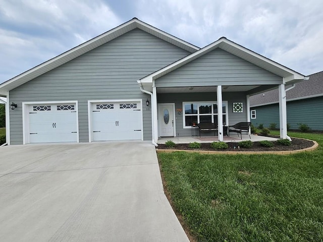 view of front of house with a porch, a garage, and a front lawn