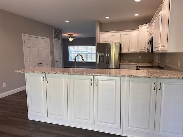 kitchen featuring sink, stainless steel appliances, light stone counters, dark hardwood / wood-style flooring, and white cabinets