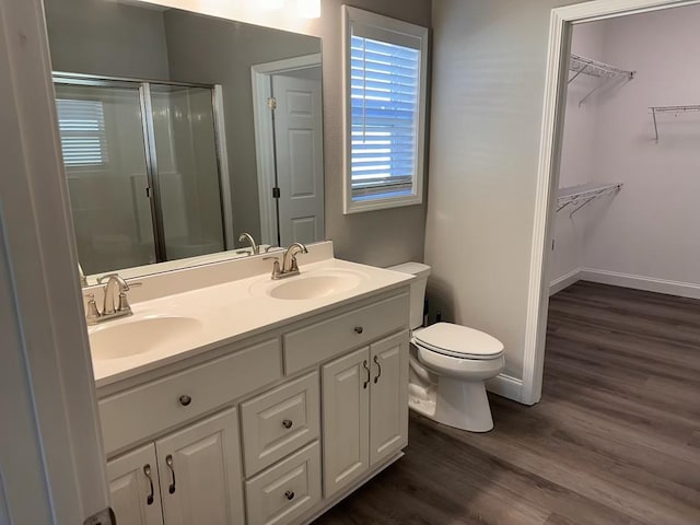 bathroom with a shower with shower door, toilet, wood-type flooring, and vanity