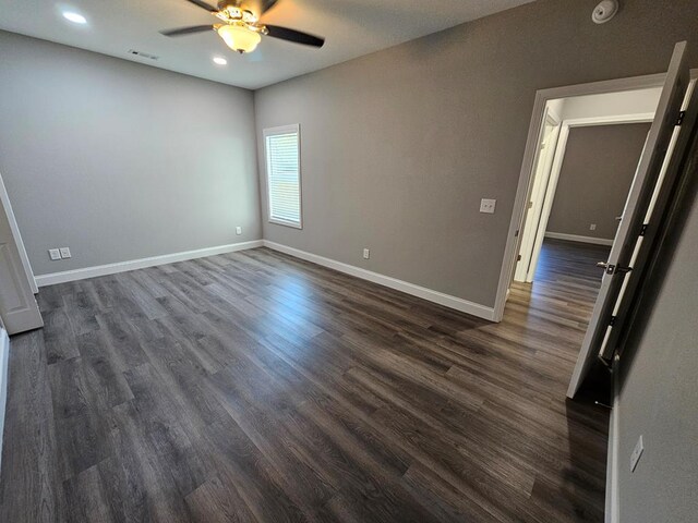 unfurnished room featuring ceiling fan and dark wood-type flooring