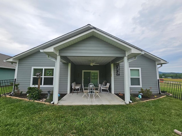 back of property with a lawn, ceiling fan, and a patio